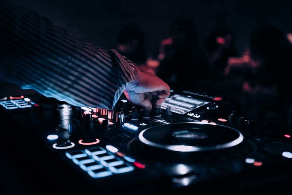 Nærbilde av en opplyst DJ-konsoll med glødende knapper i mørket